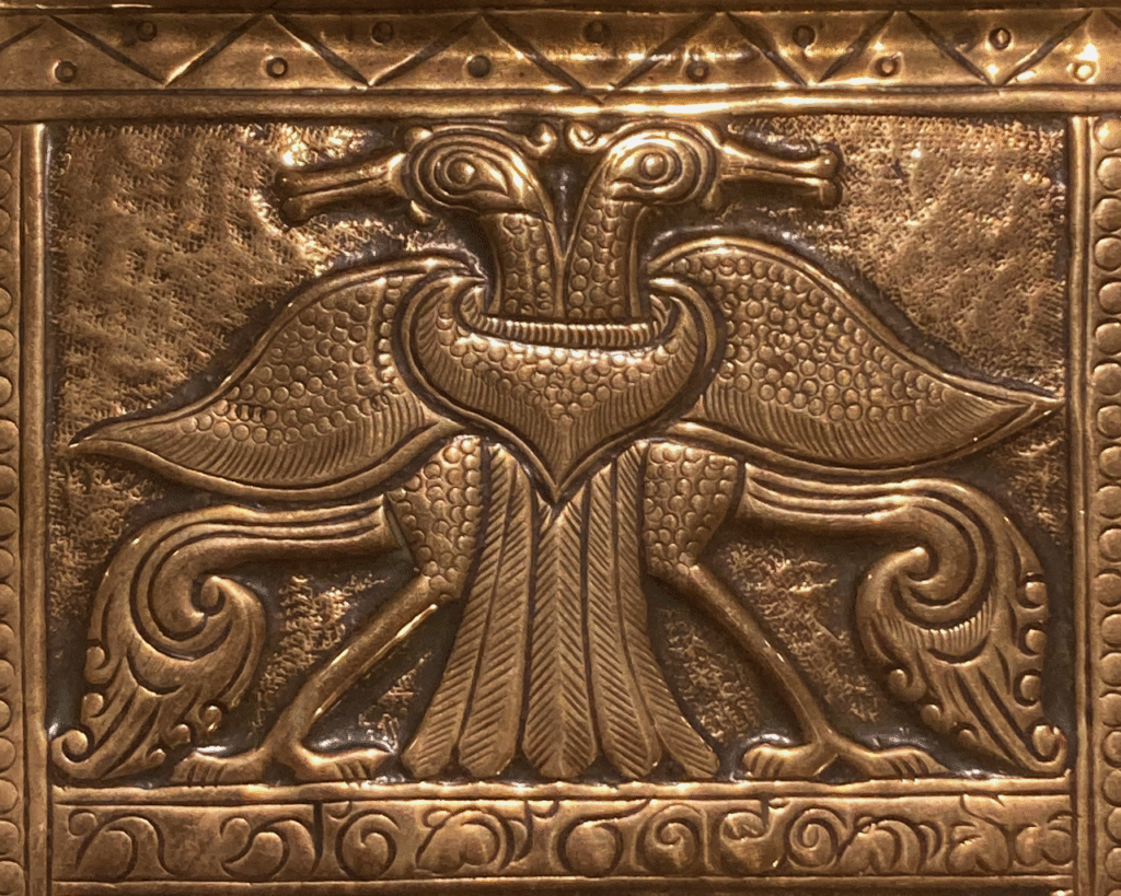 This shows a section of the tray with two birds with their bodies facing each other but their heads turned back behind them. Each bird is stylised with intricate details.