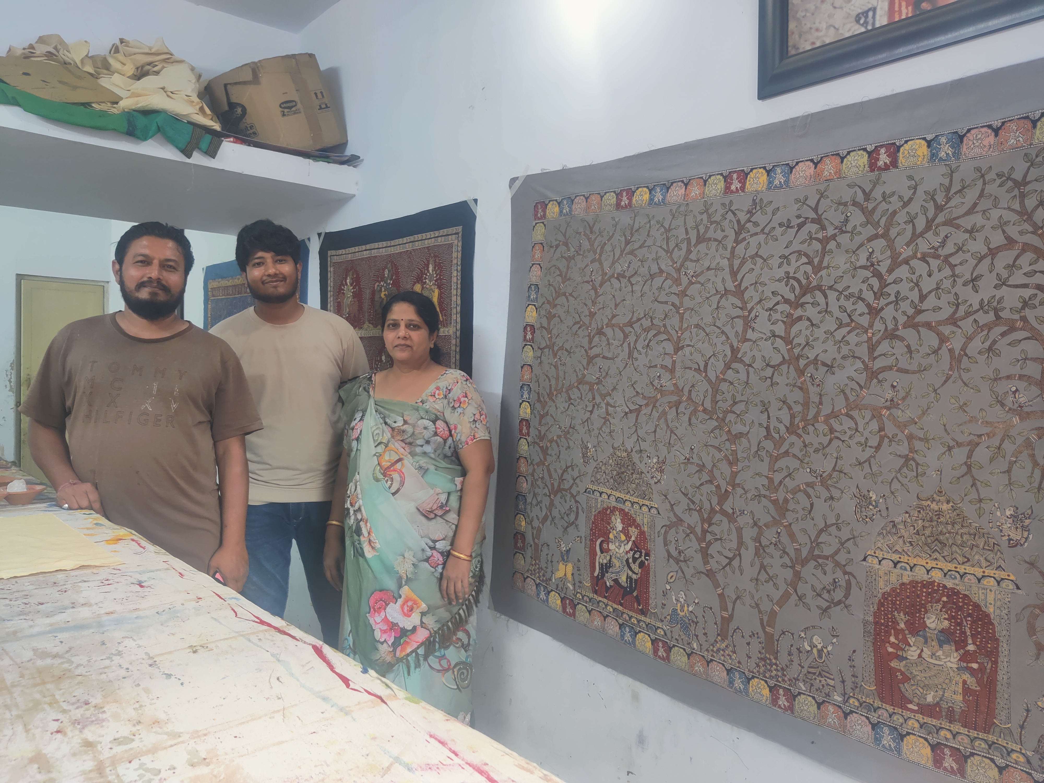 A photo of mata ni pachedi artists next to their work